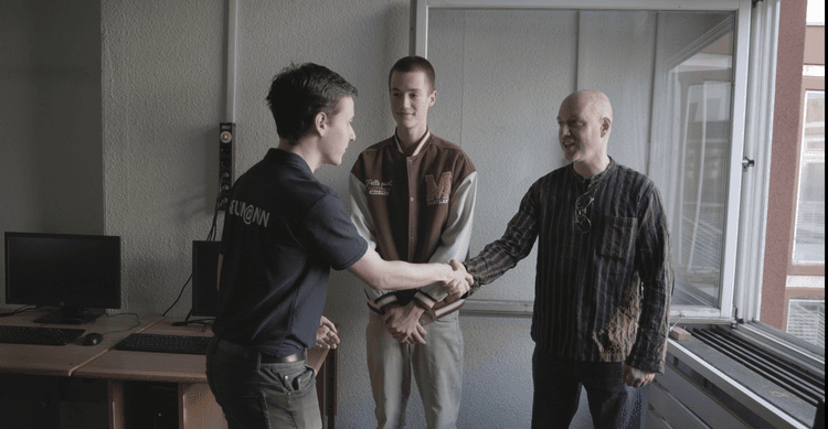 Levente Balogh shaking hands with a parent who has just been interviewed